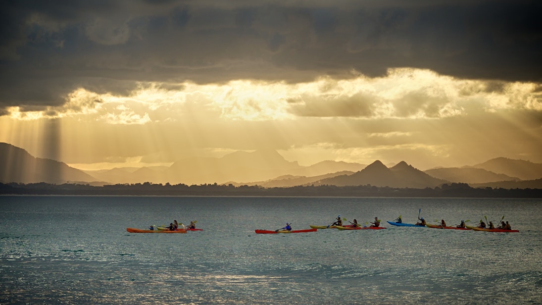 Kayakers watch for whales as the sun sets